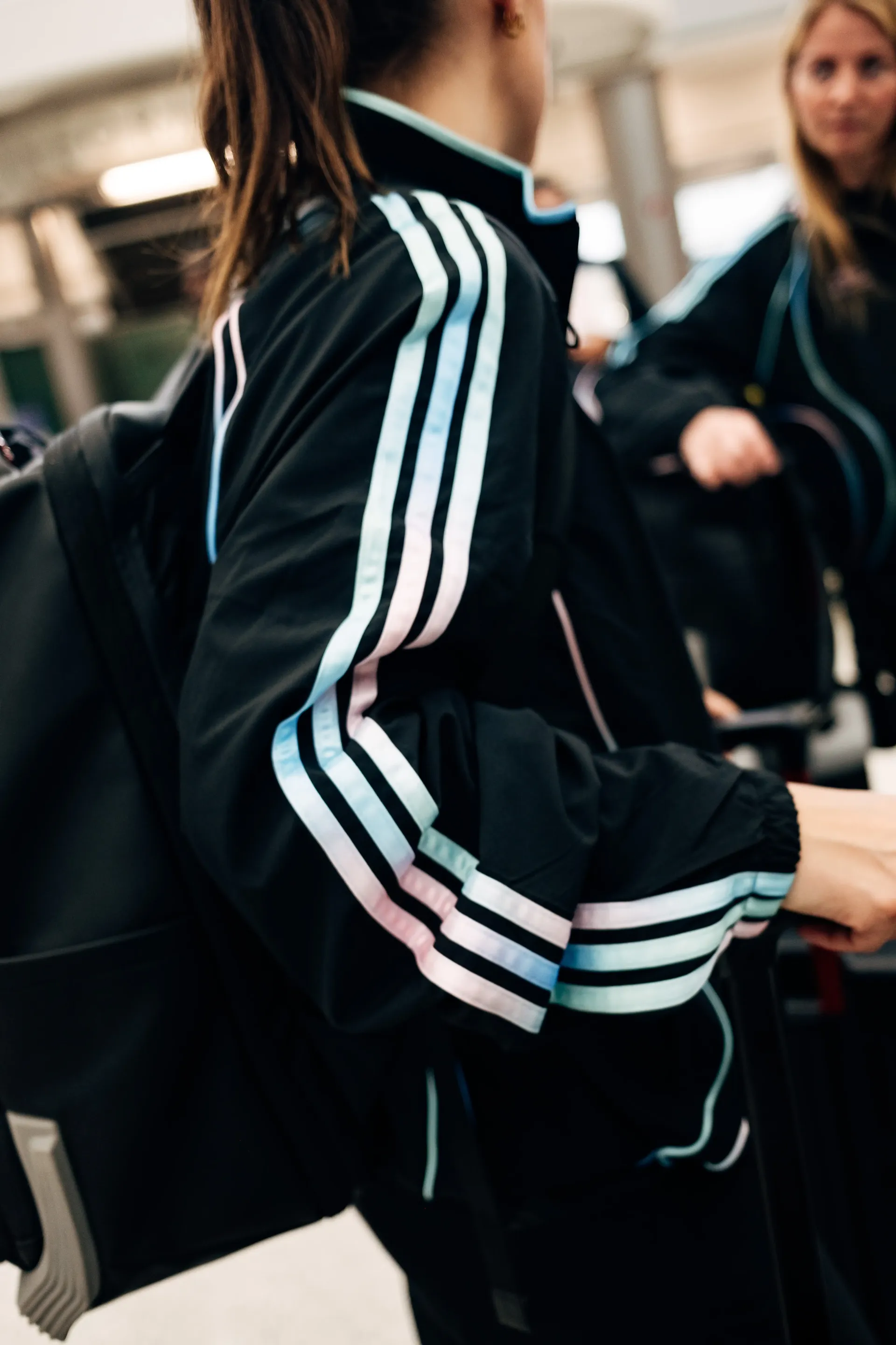 Close-up of Audi Revolut F1®Team crew member walking through terminal corridor in the new Miami collection tracksuit.