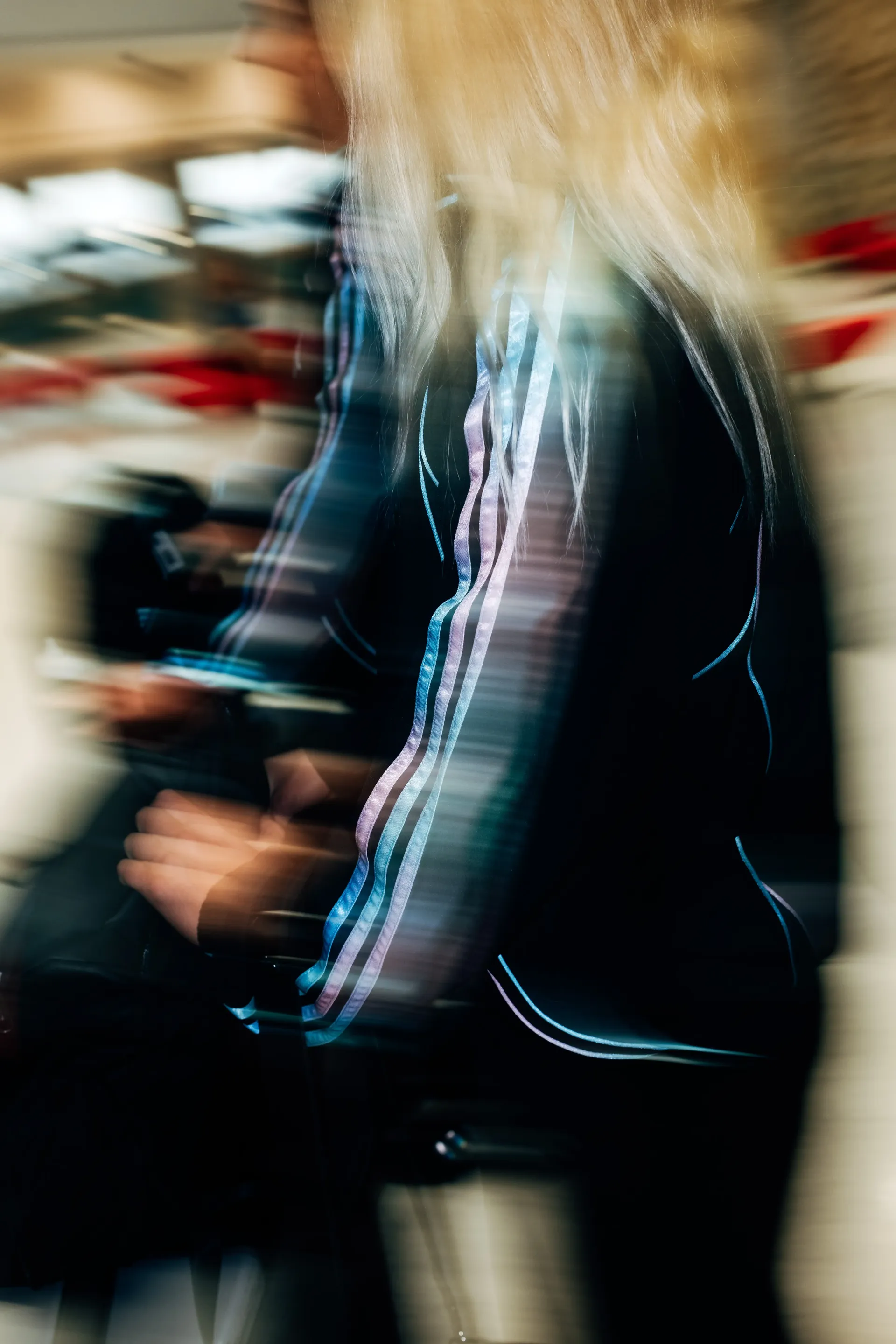 Close-up of Audi Revolut F1®Team crew walking through terminal corridor in the new Miami collection tracksuit.