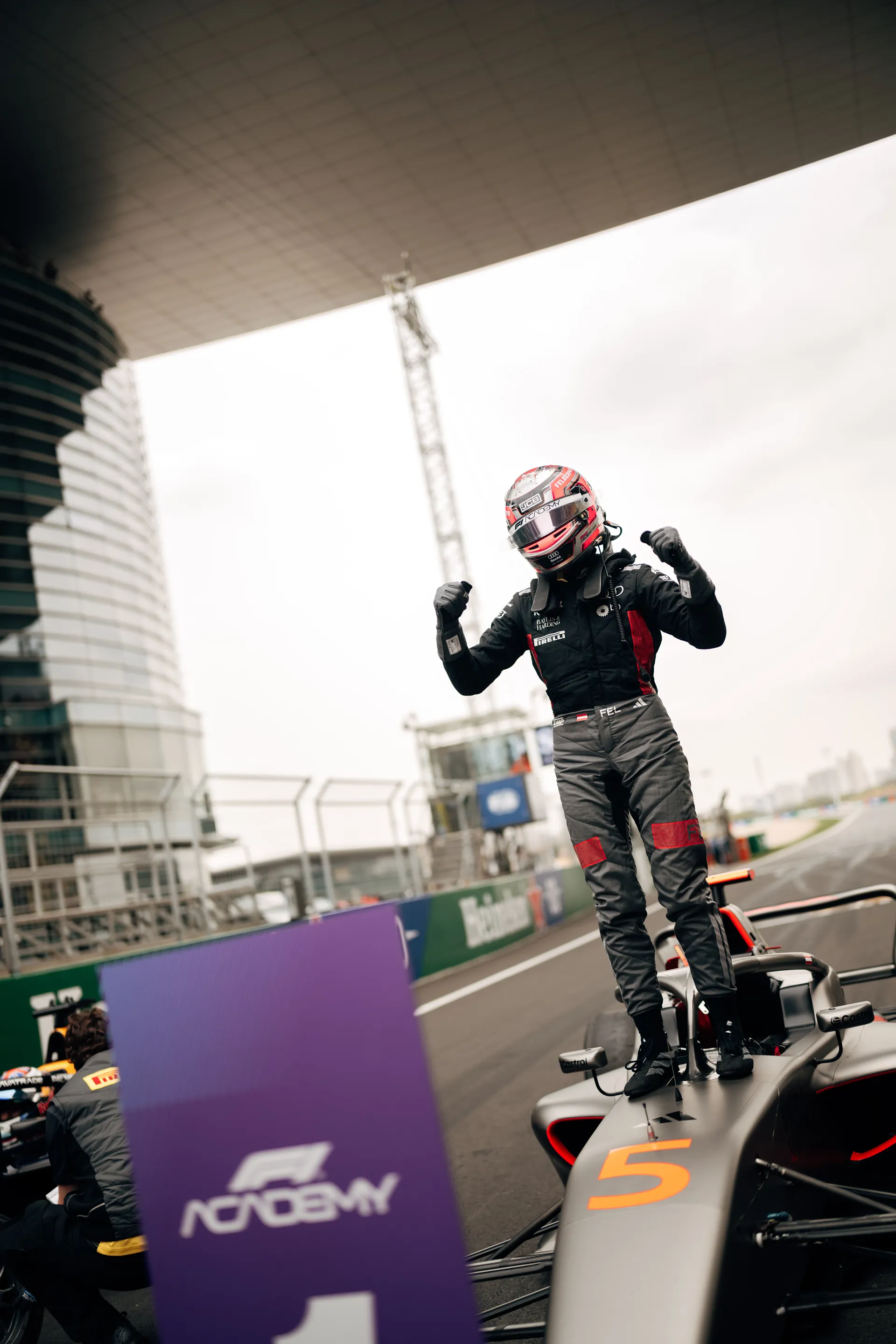 Emma Felbermayr stands on her F1 Academy car celebrating on track after Race 2 in Shanghai.